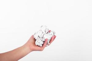 crumpled papers in the hand on white background. zero waste concept. replacement for plastic cups photo