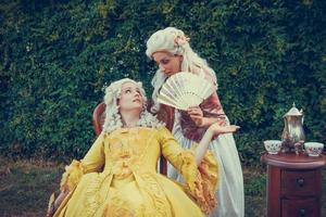 retrato de dos mujeres rubias vestidas con ropa barroca histórica