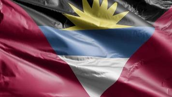Die Flagge von Antigua und Barbada weht langsam auf der Windschleife. das Banner von Antigua und Barbada wiegt sich sanft im Wind. voll ausfüllender Hintergrund. 20 Sekunden Schleife. video