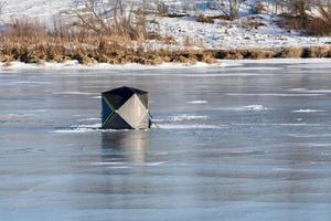 invierno en manitoba - pesca en hielo en un río congelado foto