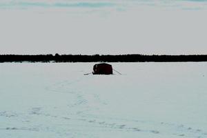 invierno en manitoba - pesca en hielo en un lago congelado foto