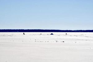 invierno en manitoba - pesca en hielo en un lago congelado foto