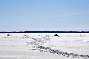 invierno en manitoba - pesca en hielo en un lago congelado foto