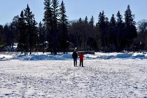 winter in Manitoba  two people walking on a frozen lake photo