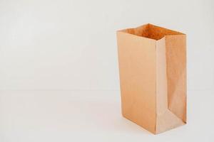 Open disposable package made of brown kraft paper on a white background. Copy, empty space for text photo