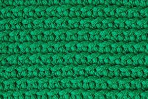 Green knitted material texture background. Top view. Copy, empty space for text photo