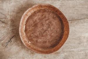 Paper craft plate with crumbs on vintage wooden background texture. Top view. Copy, empty space for text