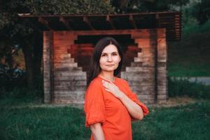 hermosa mujer vestida con ropa roja se encuentra en el fondo de una casa de madera foto