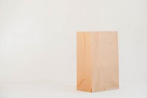 Open disposable package made of brown kraft paper on a white background. Copy, empty space for text photo