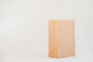 Open disposable package made of brown kraft paper on a white background. Copy, empty space for text photo