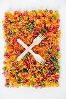 Multicolored pasta with a wooden forks as a background image. Top view. Copy, empty space for text photo