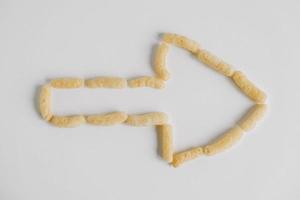 Corn sticks scattered in the shape of an pointer on a white background. Top view. Place for your text photo