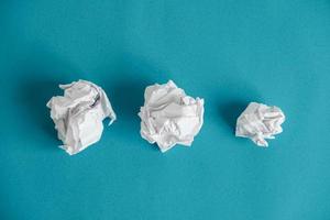 Crumpled paper balls on a blue background. Minimalist concept photo