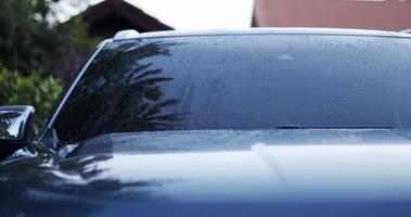 dejar caer agua sobre el coche después de lavarlo. la parte delantera del coche después de la limpieza. concepto de coche video