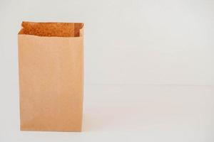 Open disposable package made of brown kraft paper on a white background. Copy, empty space for text photo