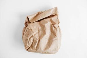 Full crumpled disposable bag of brown kraft paper on a white background. Top view. Copy, empty space for text photo