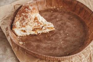 Piece of homemade apple pie in a paper plate on a wooden background photo