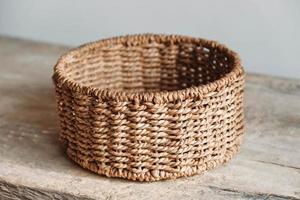 Empty round wicker basket on a old wooden table. Copy, empty space for text photo