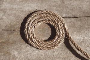 Thick rope on old wooden background. Top view. Copy, empty space for text.