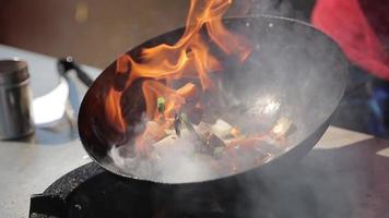 chef-kok koken met vuur in koekenpan op een straatvoedselfestival video