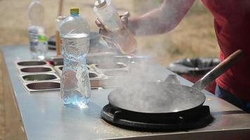 chef cocinando con fuego en una sartén en un festival de comida callejera video