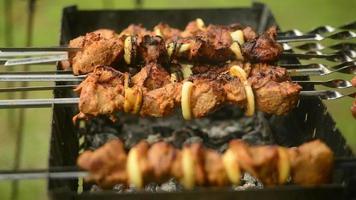 een kok gegrild vlees dat aan een spies wordt geroosterd op een straatvoedselfestival video