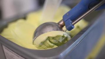 cerrar helado de pistacho sacando del recipiente a un cono