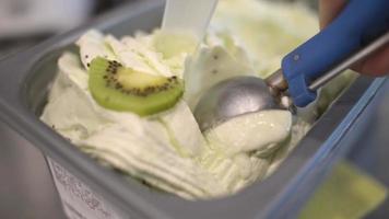 Close Up Kiwi Ice Cream Scooping Out Of Container to a Cone video