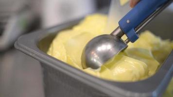 cerrar helado de mango sacando del recipiente a un cono video