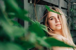 retrato de una hermosa chica rubia con belleza natural en árboles de hojas verdes. copiar, espacio vacío para texto foto