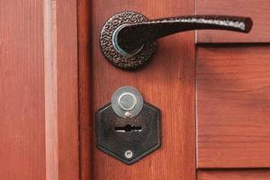 Metal hole for an old key in a wooden door. Copy, empty space for text photo