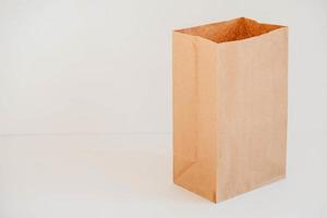 Open disposable package made of brown kraft paper on a white background. Copy, empty space for text photo