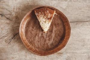 Piece of homemade apple pie in a paper plate on a wooden background photo