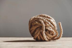 Brown ball of rope on old wooden background photo
