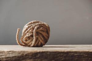 Brown ball of rope on old wooden background photo