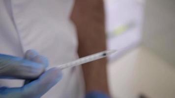 Surgeon picks up a Syringe of Solution for Injections of Botox under the Skin