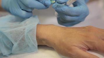 jeringa de inyección de aguja de botox debajo de la piel de la mano de la mujer, procedimiento de apriete