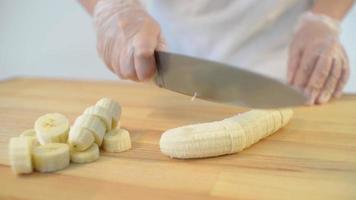 de bakker snijdt een banaan met een mes video