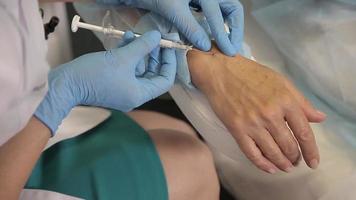 seringue d'aiguille de botox d'injection sous la peau de la main de la femme, procédure de serrage