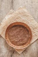 Paper craft plate with crumbs on vintage wooden background texture. Top view. Copy, empty space for text photo