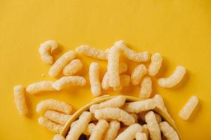 Corn sticks in a yellow bowl on a yellow background. Top view. Place for your text photo