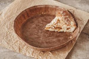 Piece of homemade apple pie in a paper plate on a wooden background photo