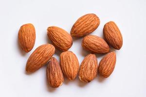 almendras en la vista superior de fondo blanco en la mesa, cierre las nueces de almendras tostadas alimentos proteicos naturales y para la merienda foto