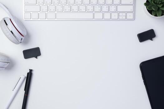 top view working desk with keyboard headphone and mobile phone on white table background photo