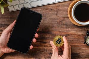 hand holding mobile and  bitcoin crypto currency to trading in stock market.defi on blockchain photo