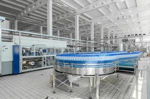 Tashkent, Uzbekistan - June 7, 2016 - Plant for the production of plastic bottles.  Plastic bottles on a conveyor belt. Bottled water filling photo