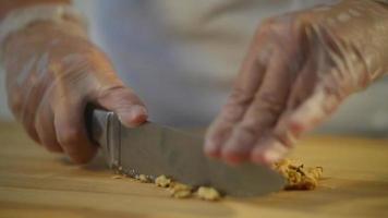 Bäcker schneidet mit Messer Walnüsse für einen Kuchen video