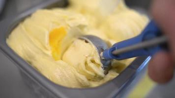 cerrar helado amarillo afrutado sacando del recipiente a un cono