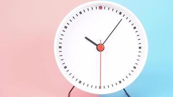 despertador isolado no fundo azul rosa, o tempo começa a andar às 11 horas. video