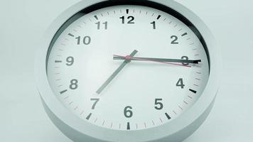 time lapse, l'horloge murale blanche indique l'heure .rotation des aiguilles courtes et longues de l'horloge. sur le fond blanc. video